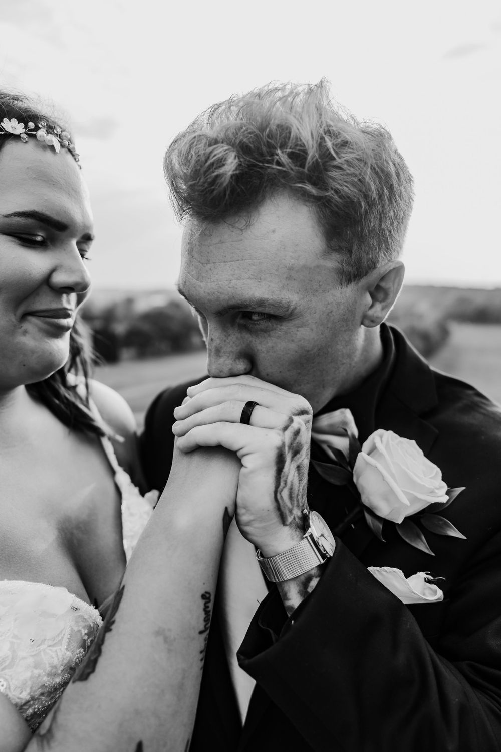 An intimate black and white moment between newlyweds sharing a tender gesture.