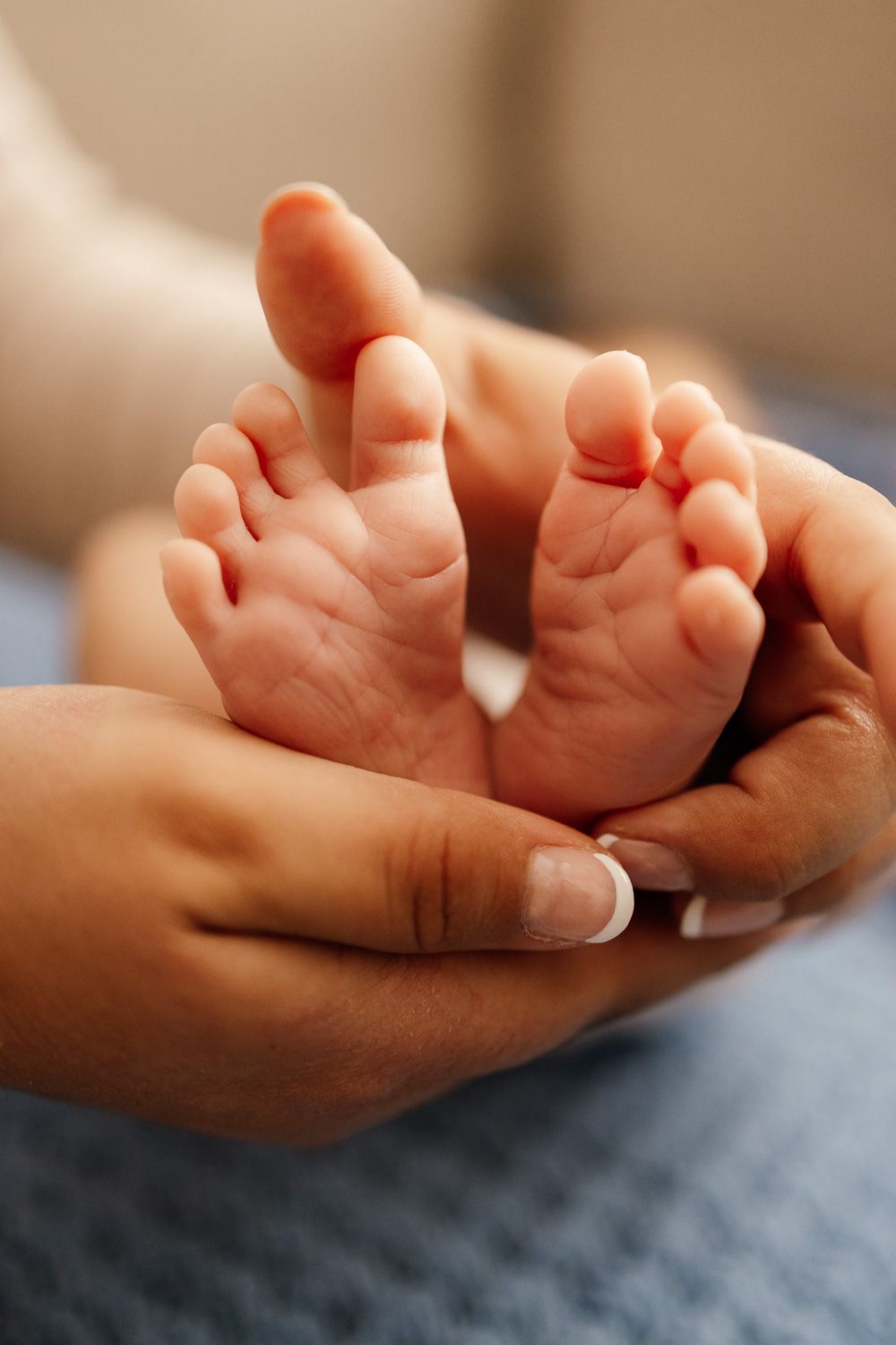 Bay Area Newborn Photographer Cindy Tucey photographs mom cradling baby's feet at in-home lifestyle newborn session