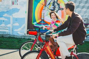 A red electric bicycle parked on a city street against colorful outdoor murals in Washington DC.