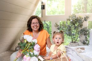 A heartwarming moment of laughter and bonding in a sunlit porch surrounded by flowers.