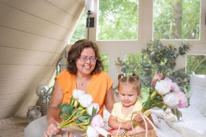 A cheerful scene with flowers and smiles in a bright sunroom setting.