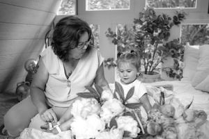 A tender black and white portrait showing a shared moment among flowers and natural light.