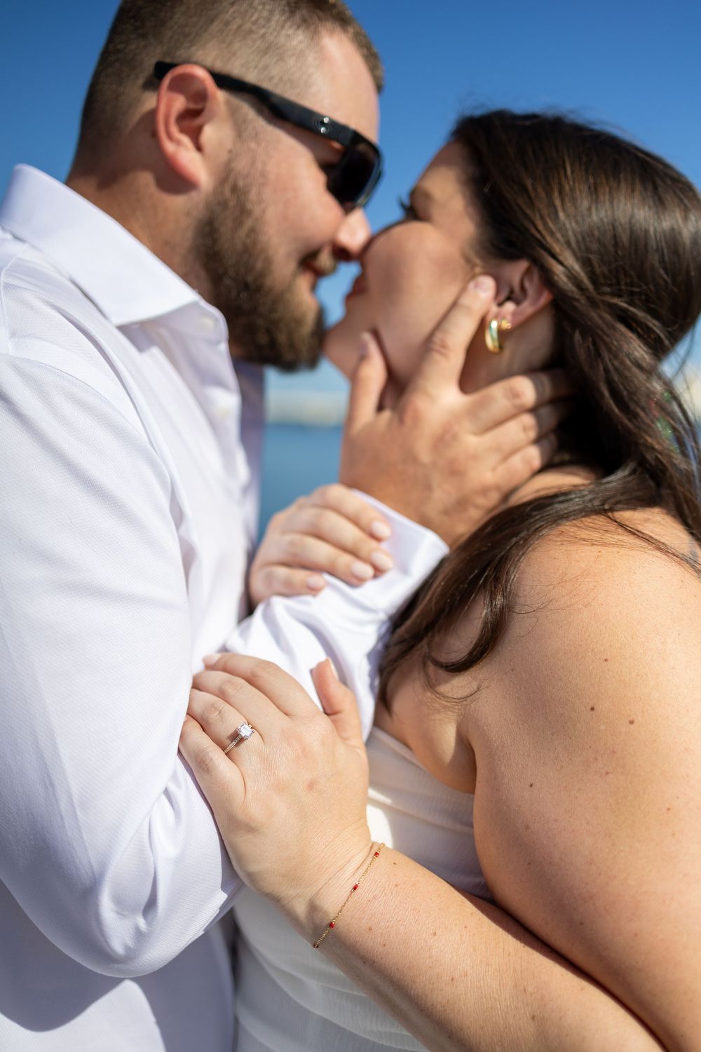 Intimate close-up of a couple sharing tender moments by the ocean.