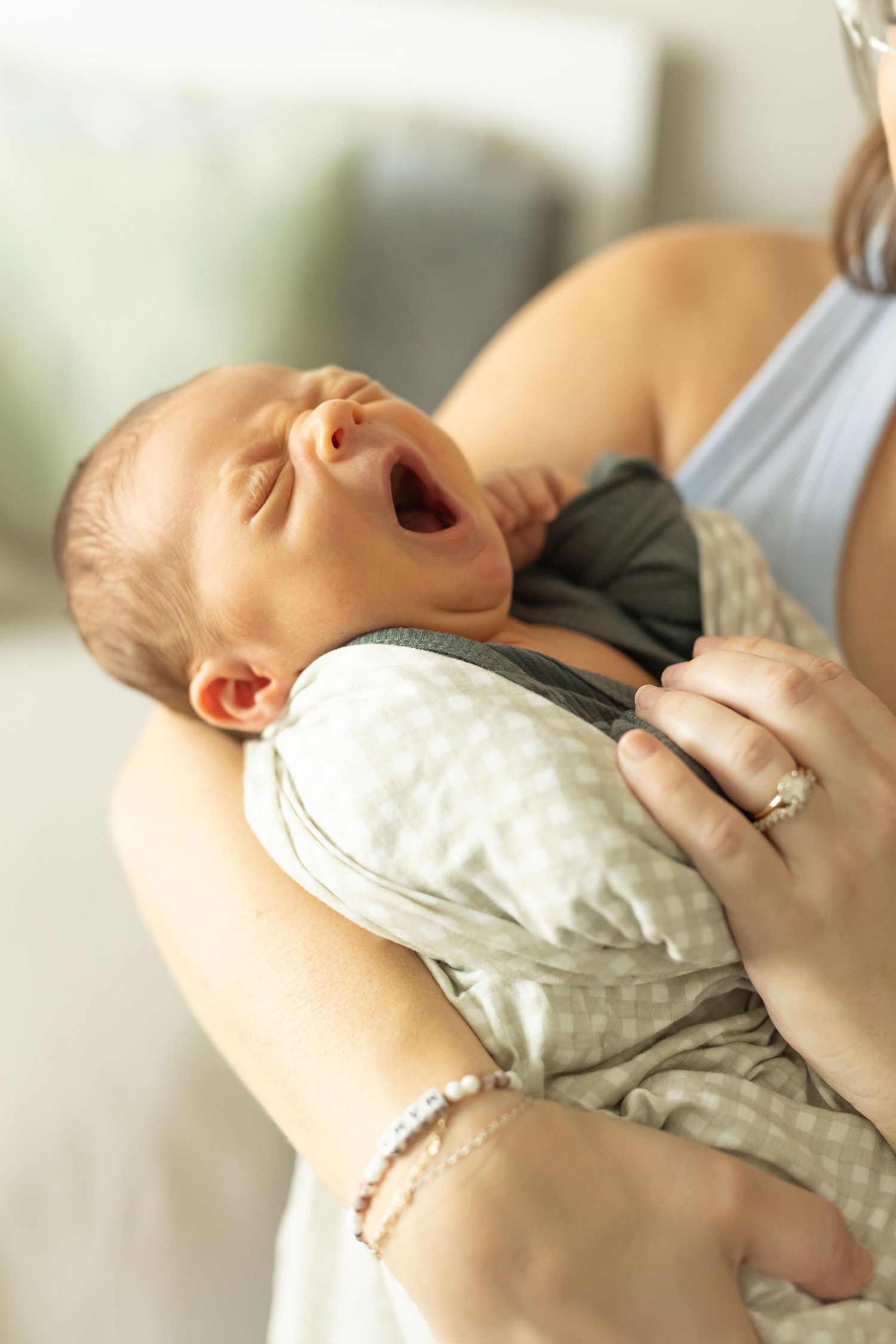 Yawning baby boy in his mother's arms
