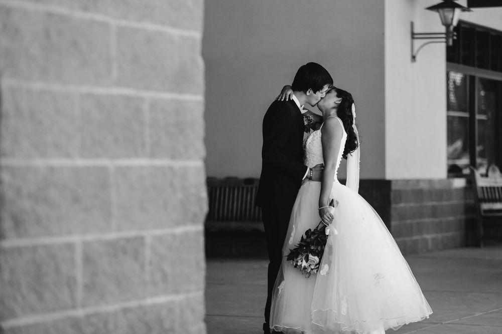 Black and white collage of wedding moments showing bride in white dress and groom in dark suit against architectural backdrop.