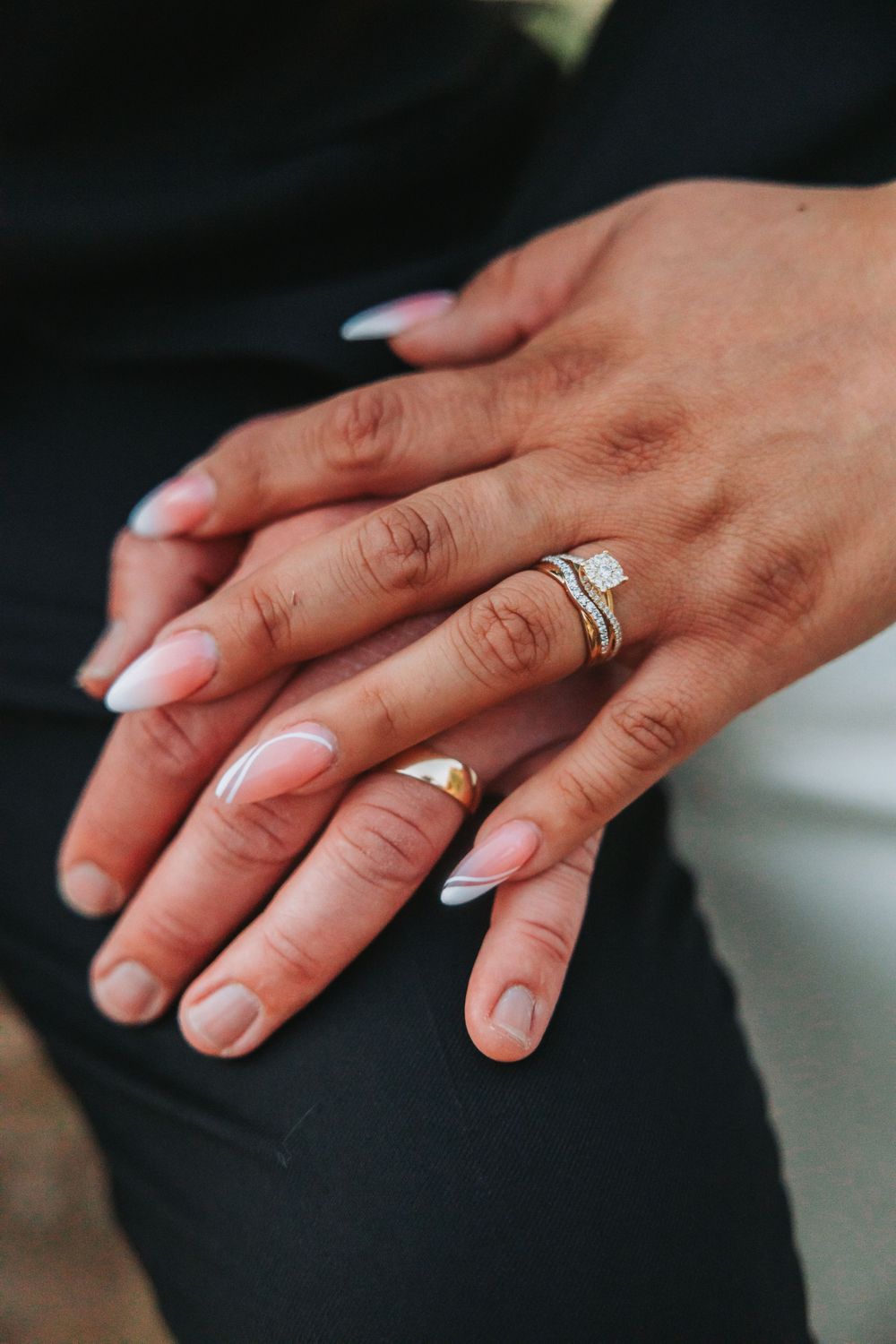 Close-up shots of hands displaying wedding rings and French manicured nails against a dark background.