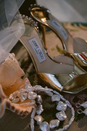 Jimmy Choo high heel shoes and crystal jewelry arranged for a luxurious wedding detail shot.