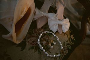 Two wedding rings sit nestled in a decorative floral display with white flowers and greenery.