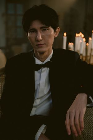 Elegant black tuxedo with bow tie photographed in candlelit setting.