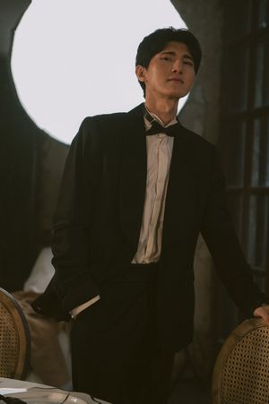 Elegant formal portrait with vintage furniture and dramatic lighting.