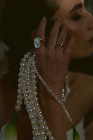Close-up of elegant pearl necklace and jewelry against dark background.