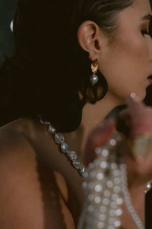 Close-up shot of sparkling crystal earrings and elegant hairstyle in dramatic lighting.