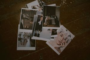 Collection of vintage-style polaroid wedding photographs scattered on dark surface.