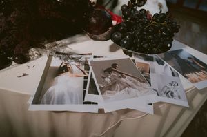 Wedding detail shots and photographs scattered on light surface.