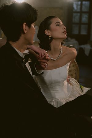 Intimate wedding portrait with dramatic lighting and elegant formal attire.