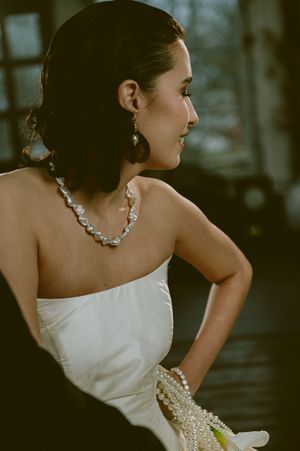 Side profile wedding portraits highlighting strapless gown and statement jewelry.