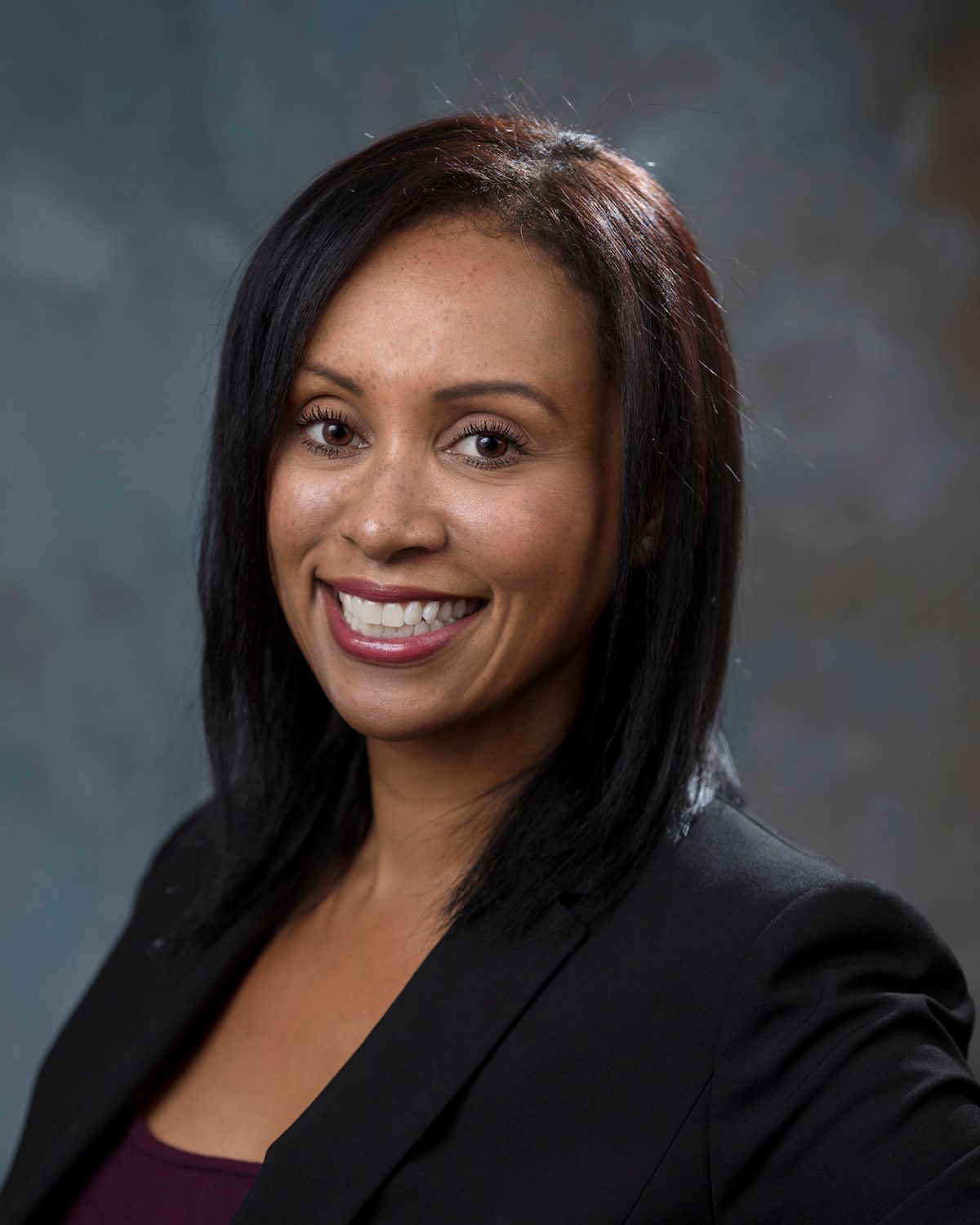 Professional portrait series of person in dark blazer against dramatic studio backdrop.