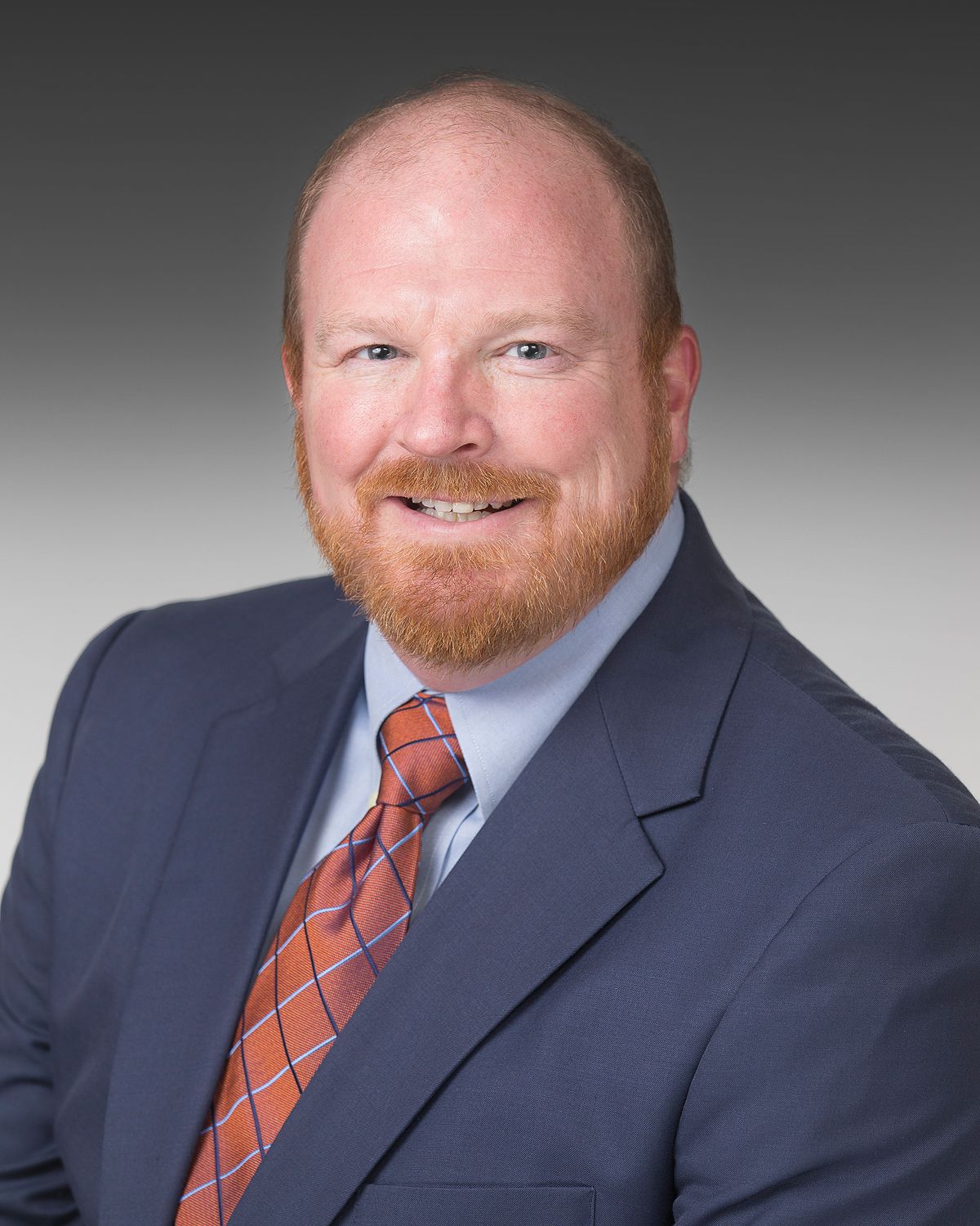 Professional headshot series of person in navy suit and orange striped tie against gradient background.