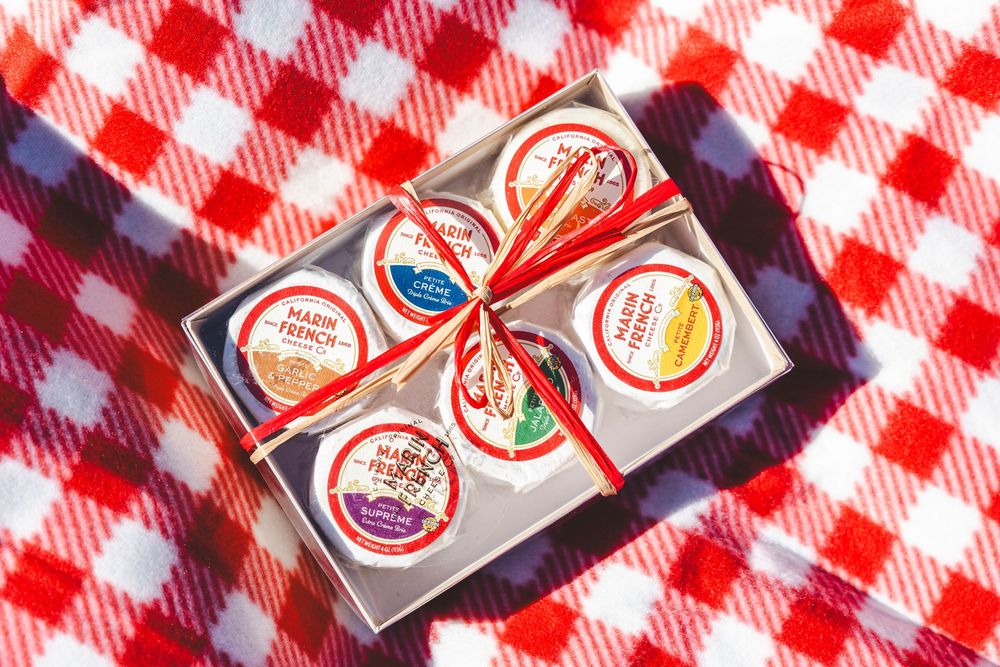 Colorful bottle caps arranged in a row on a red and white checkered gingham tablecloth background.