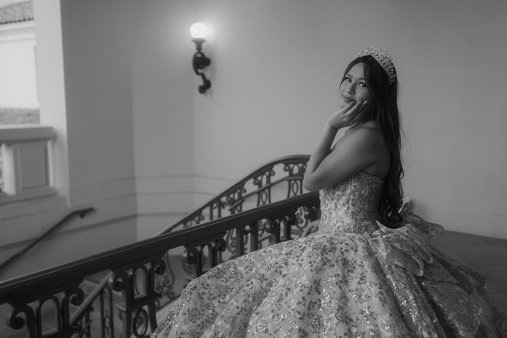 Monochrome artistic bridal portrait series showing a woman in an elegant ballgown on an ornate staircase.
