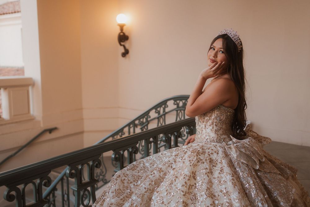 Elegant strapless ballgown with intricate lace and crystal details sparkles in romantic indoor staircase setting.