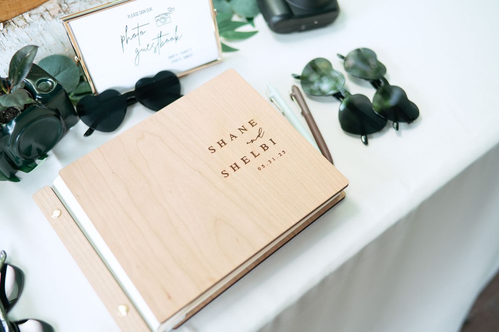 Pale peach-colored notebook journals with eucalyptus leaves arranged on a white marble surface.
