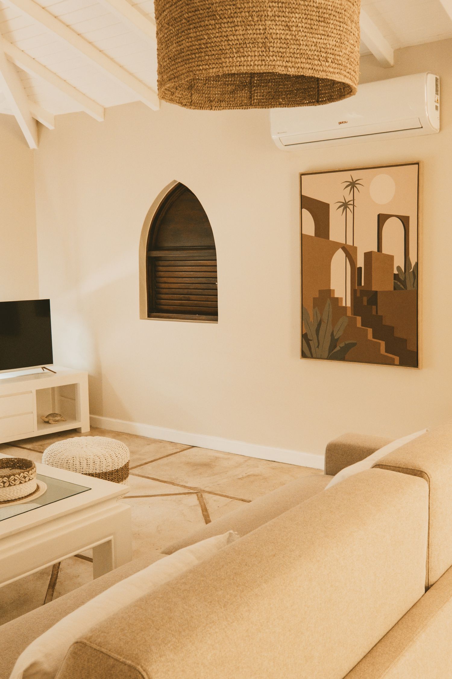 Modern spa massage room with sleek beige decor, woven pendant lights, and multiple treatment beds.