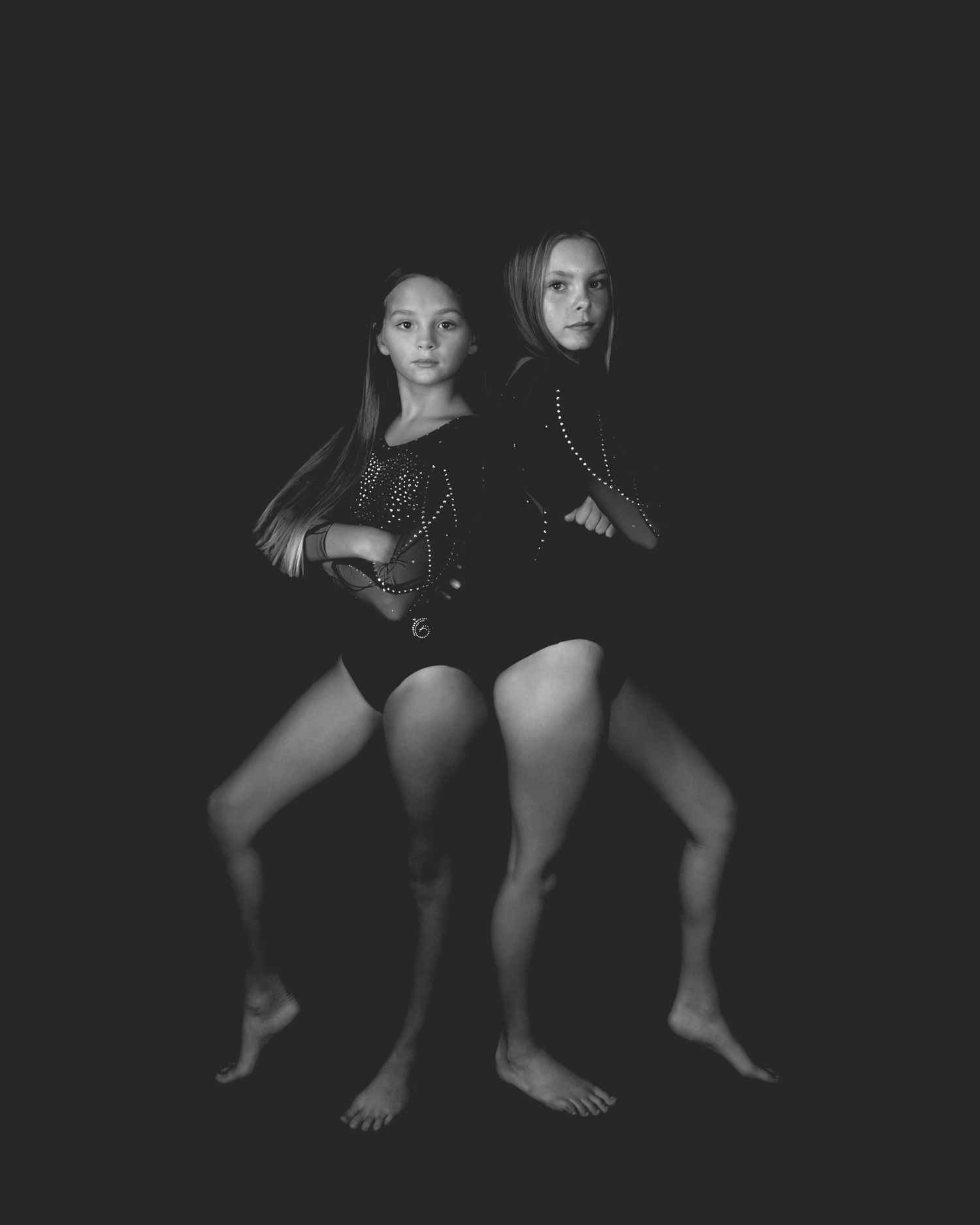 A series of monochrome photographs showing feet and legs against a black background in artistic poses.