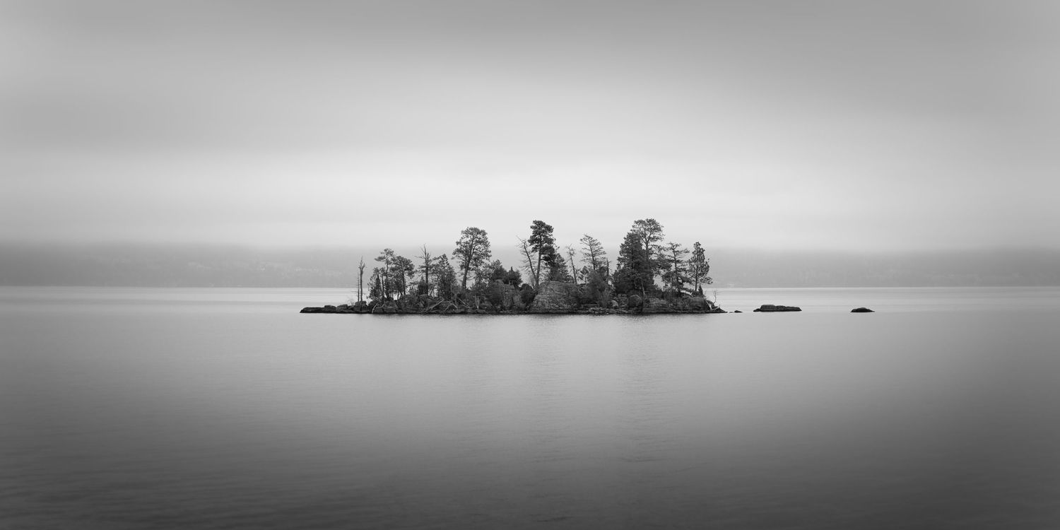 Black and white photo of Goose Island on Flathead Lake in Montana emerging from the fog