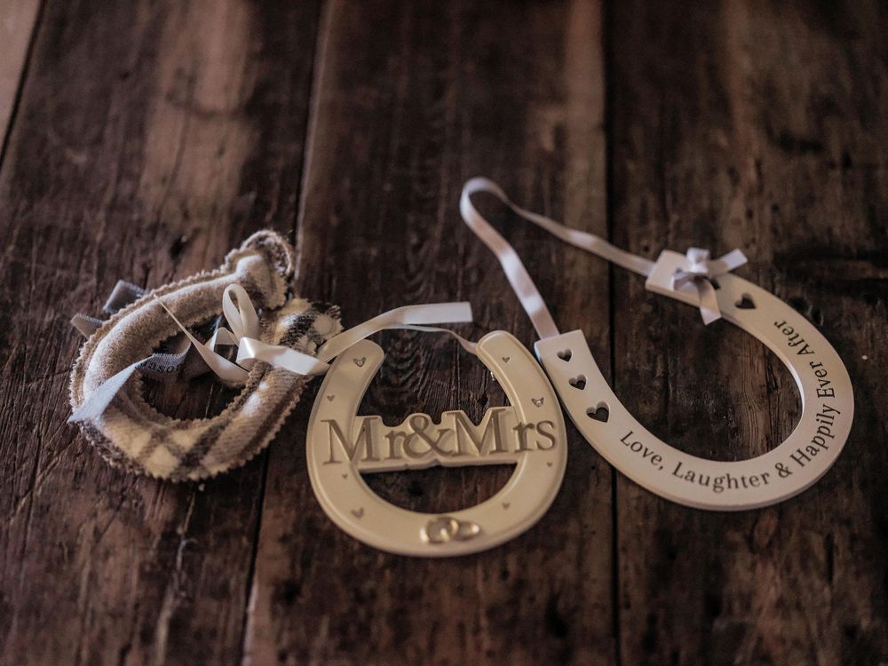 Seven rustic wooden heart-shaped ornaments with text engraving arranged in a row against a dark background.