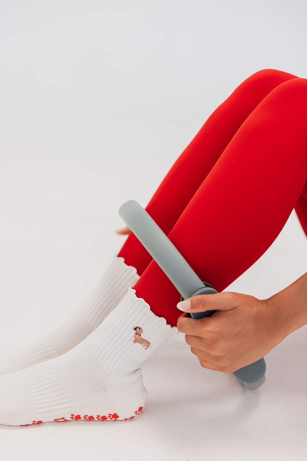Pilates reformer equipment with grey padding and white grip socks visible.