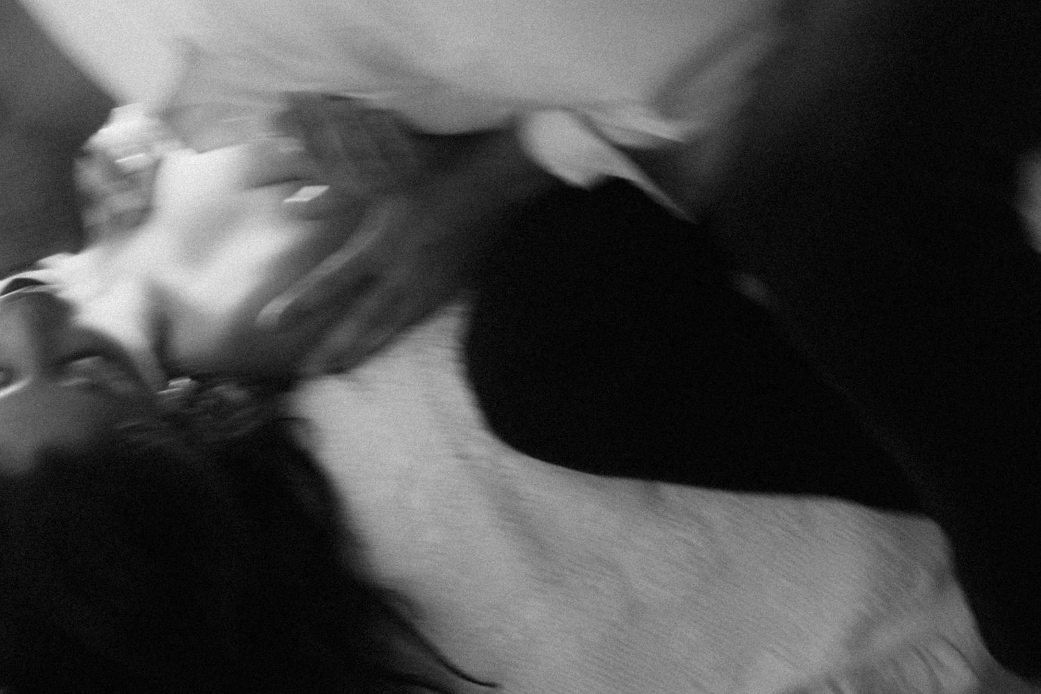 A black and white artistic photograph showing a person in movement with soft, blurred edges creating a dreamy effect.