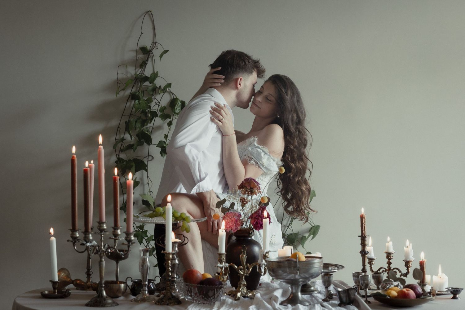 Romantic candlelit wedding scene with elegant floral arrangements and tapered candles on a rustic table setting.