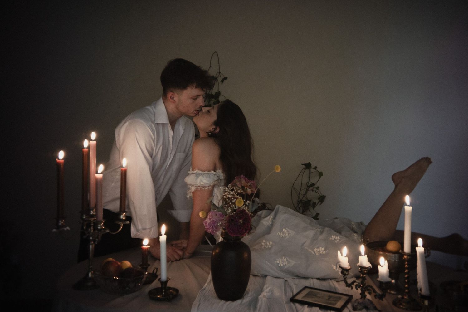 A romantic candlelit dinner setting with glowing candles and intimate lighting creates an elegant atmosphere.
