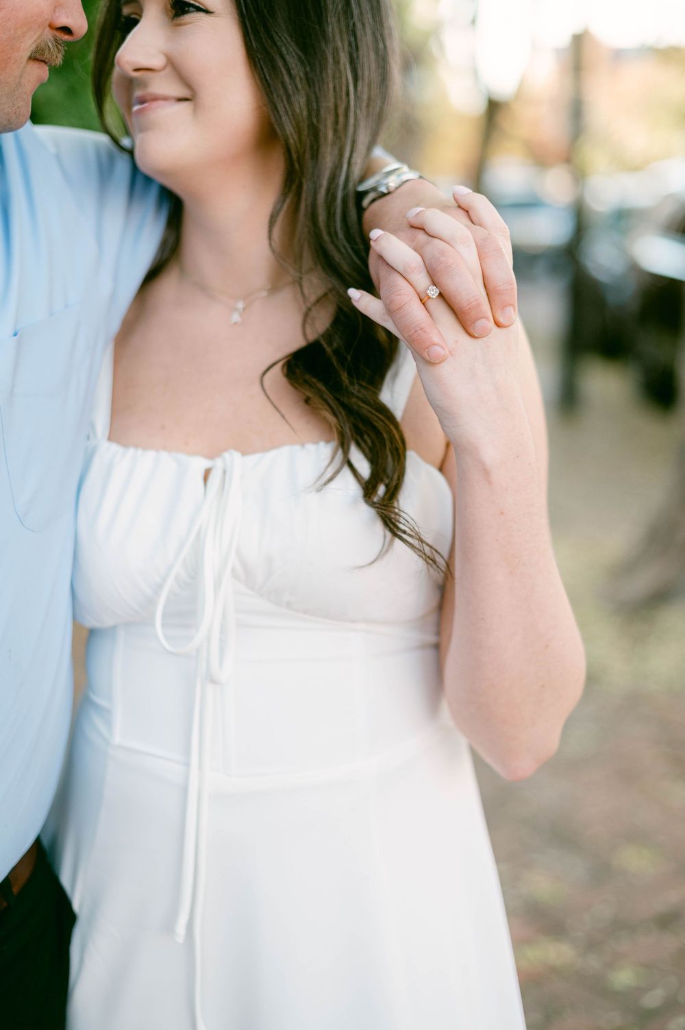 Close-up shot of couple showing affection and holding hands during engagement photos.