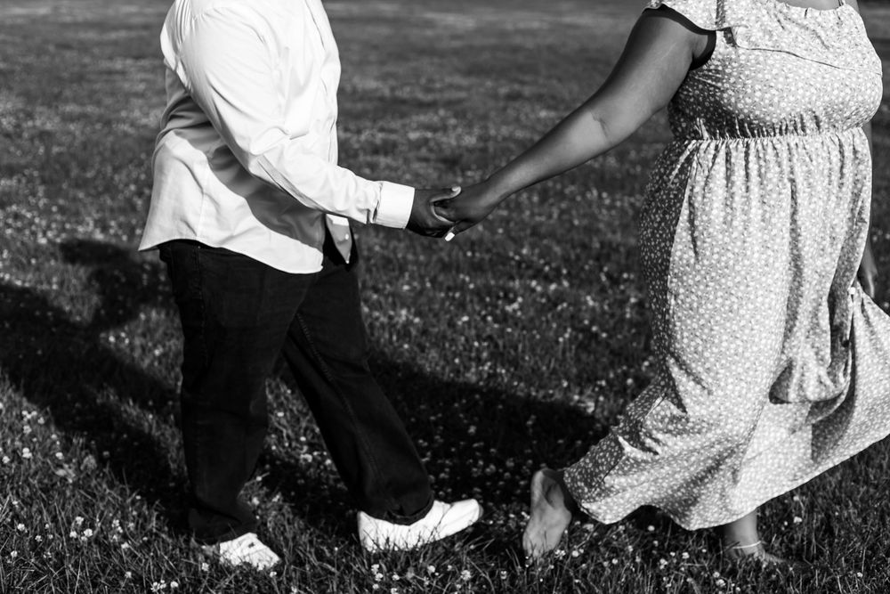 A black and white image showing two people dancing together on grass, focused on their footwork.