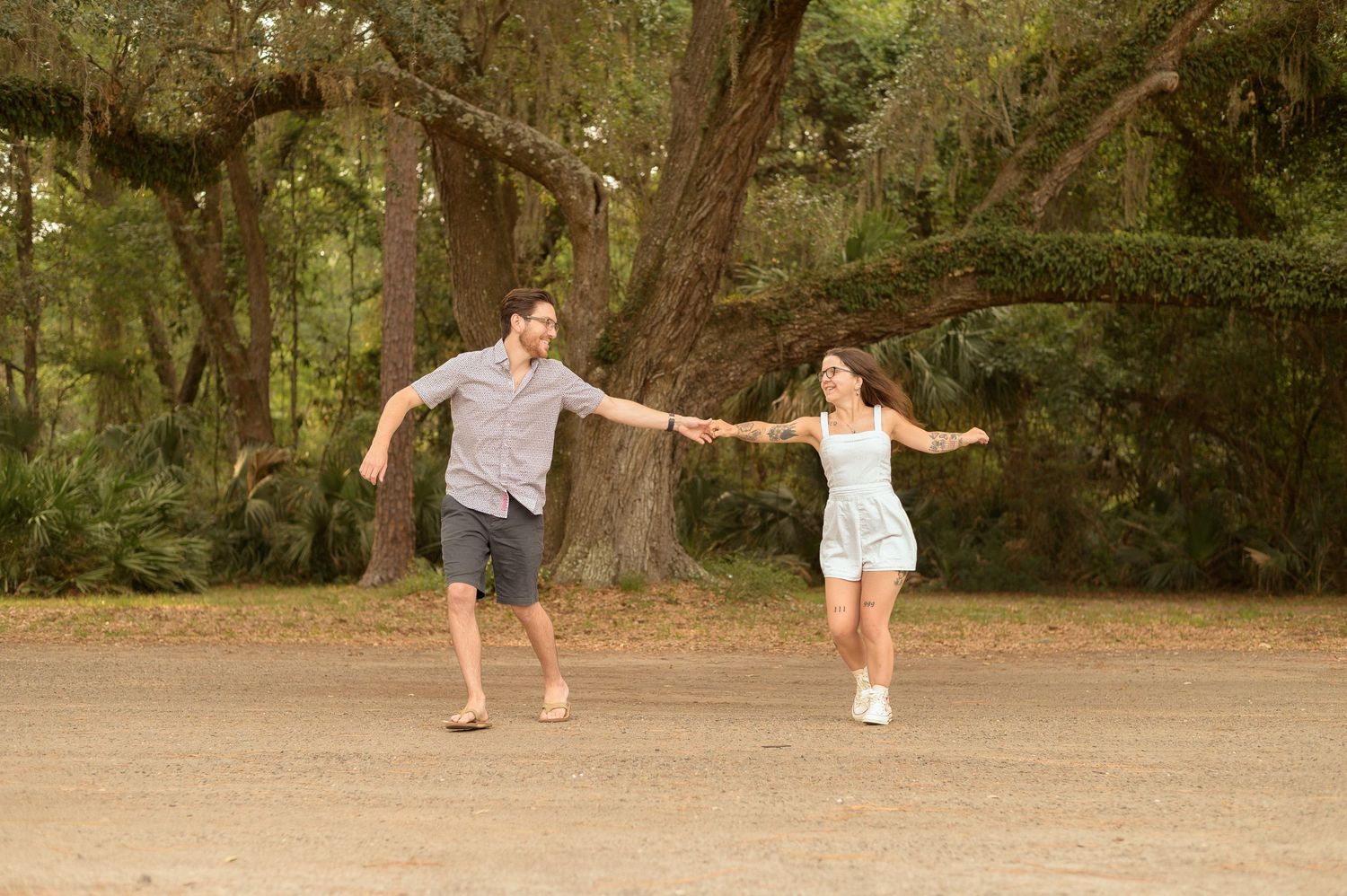 A couple performs dance moves together on a dirt path in a wooded area during a photo sequence.