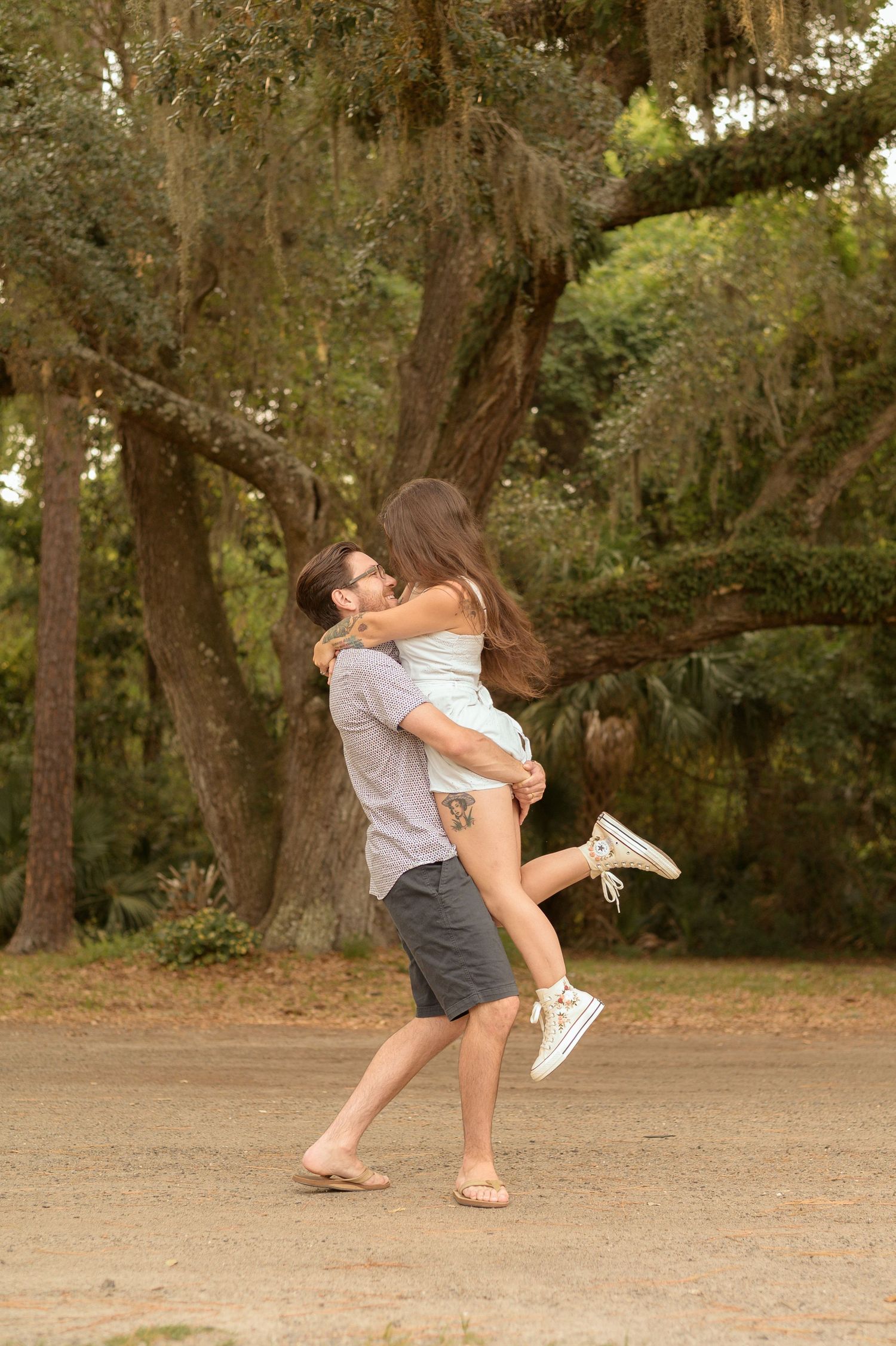 A playful sequence of dance moves shows a couple in casual attire performing a dip in a wooded outdoor setting.