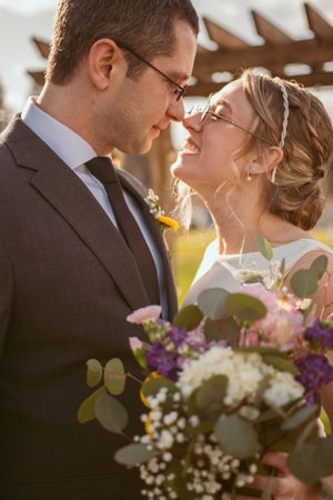 Close up shot of a romantic wedding bouquet with purple flowers, white blooms and eucalyptus leaves.
