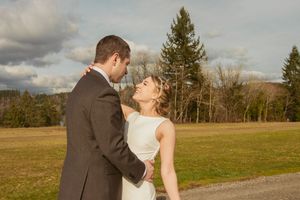 A couple in wedding attire share sweet romantic moments in a rustic outdoor field setting during golden hour.
