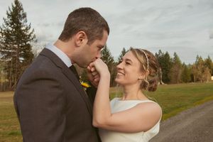 A romantic countryside wedding photo session with evergreen trees and a winding rural road in the background.