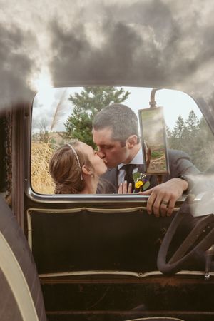 Romantic vintage car moment captured through the window on a cloudy afternoon.