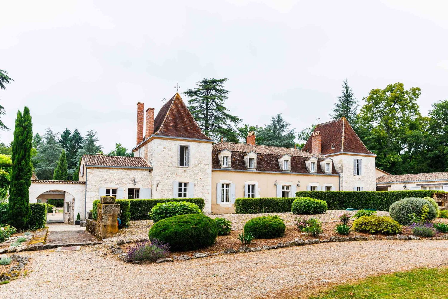 A panoramic view of a rustic French countryside estate with elegant stone buildings and manicured gardens.