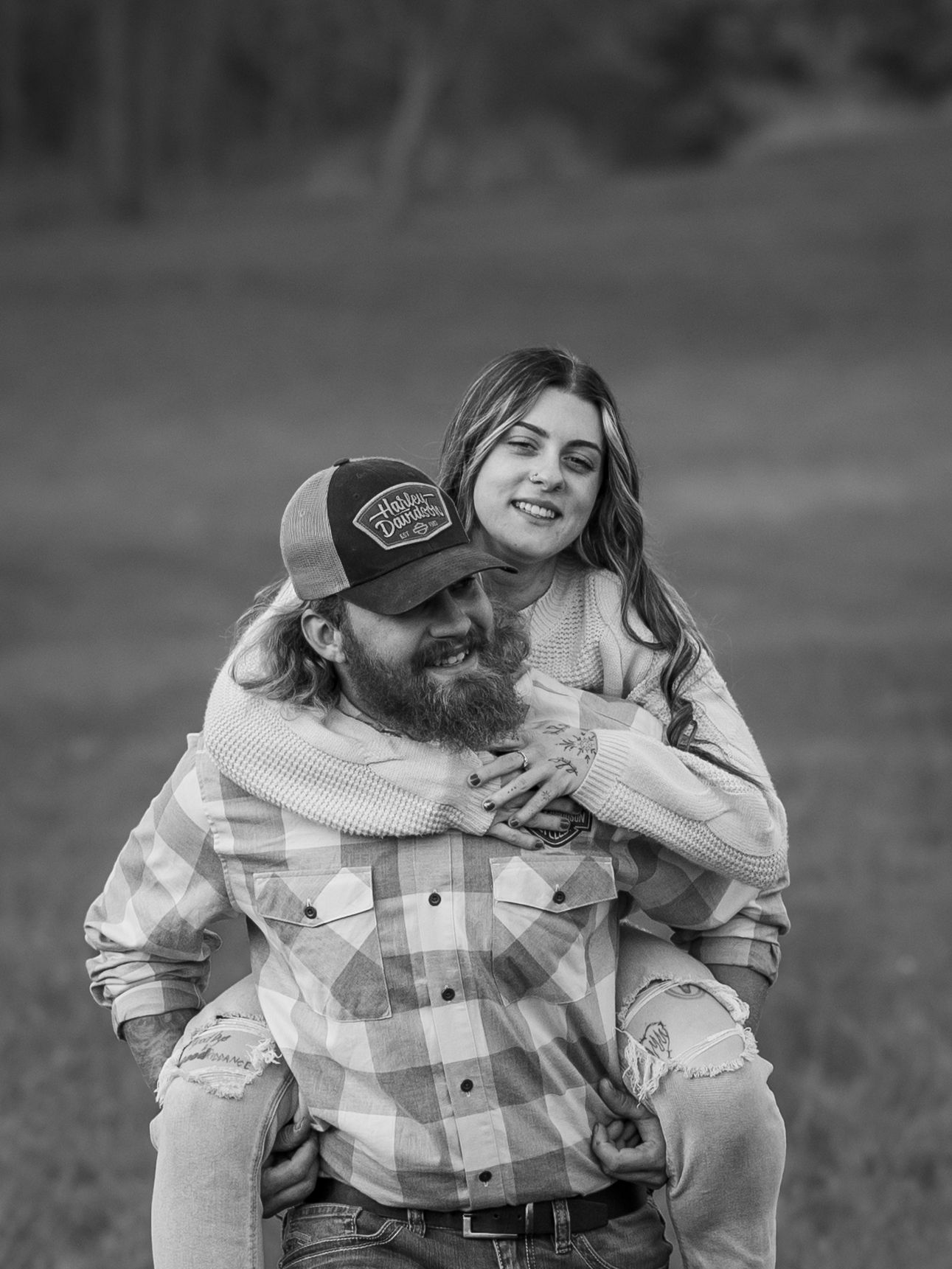 Black and white photo of couple sharing intimate moment outdoors.