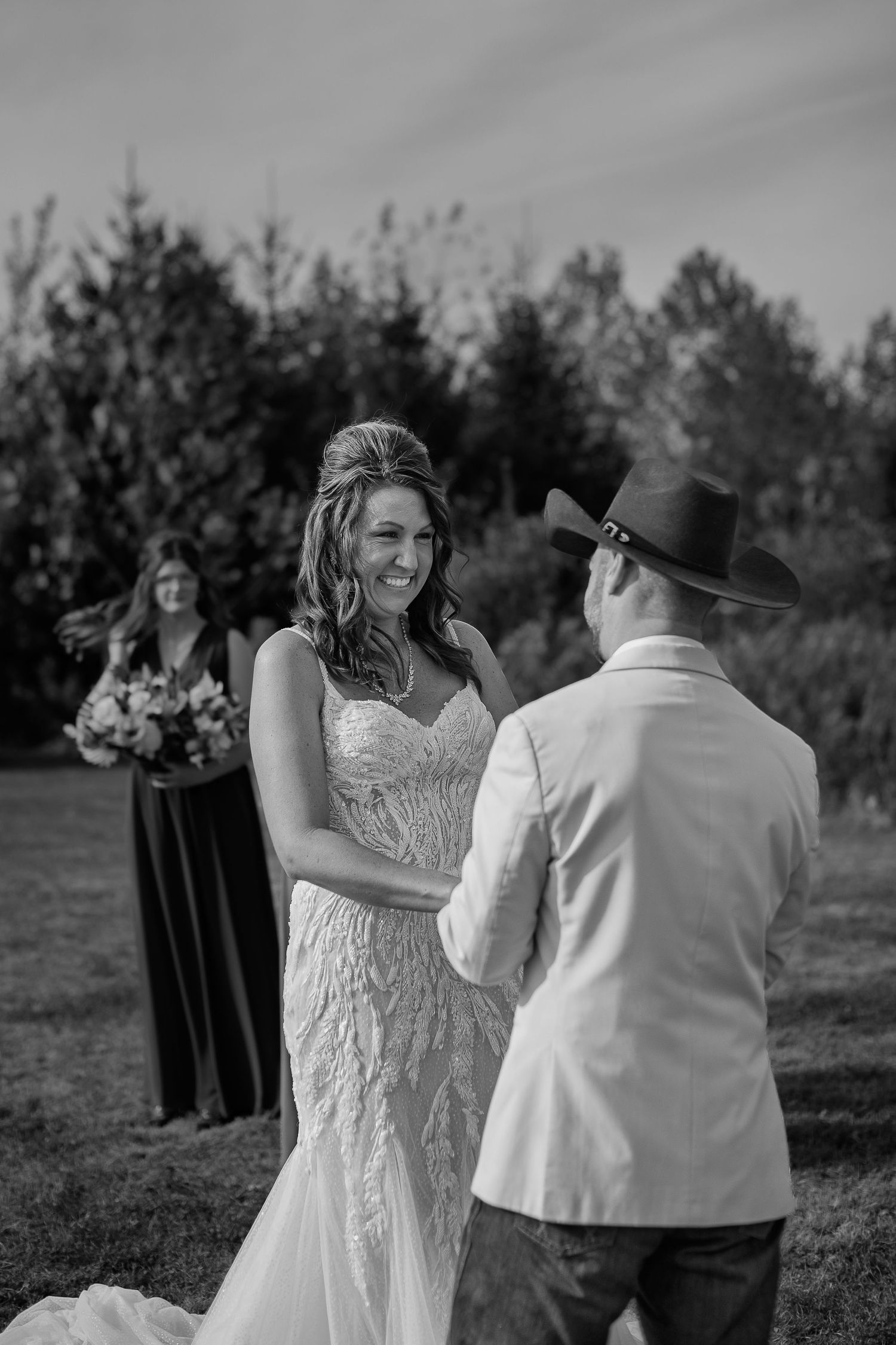 A couple dancing together outdoors during a wedding celebration with guests watching in the background.