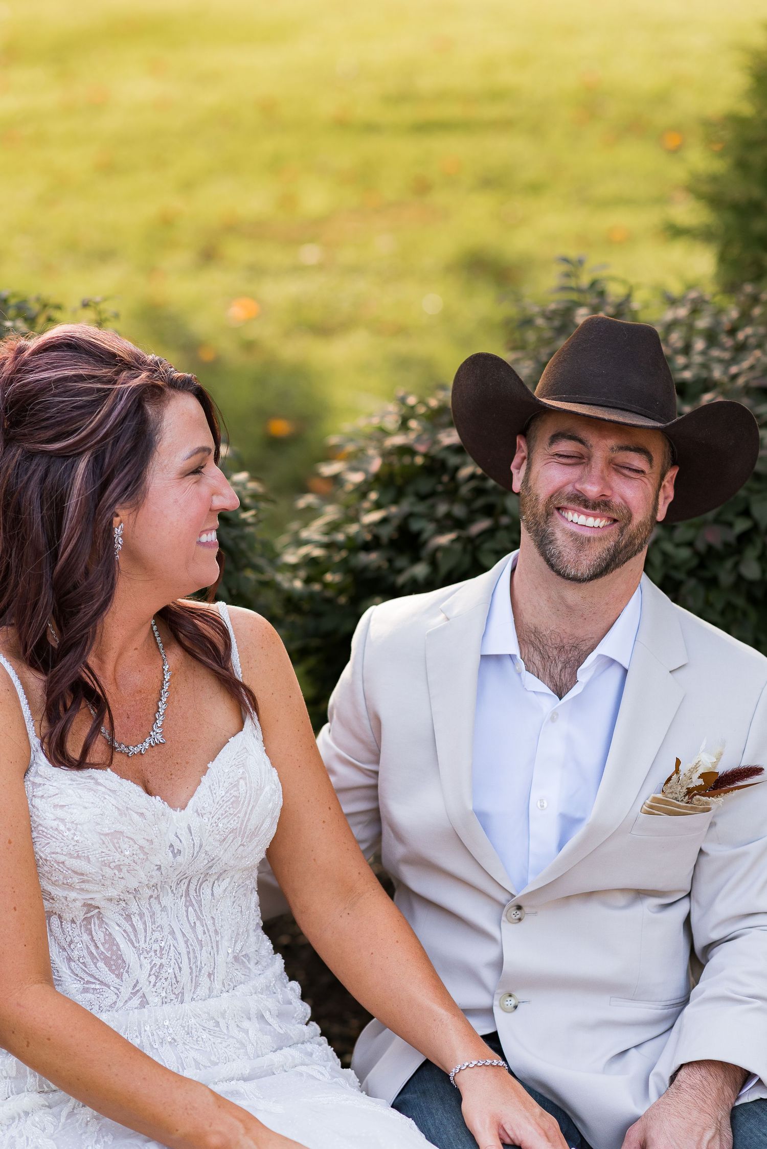 A couple shares a candid laughing moment together on a sunny afternoon.