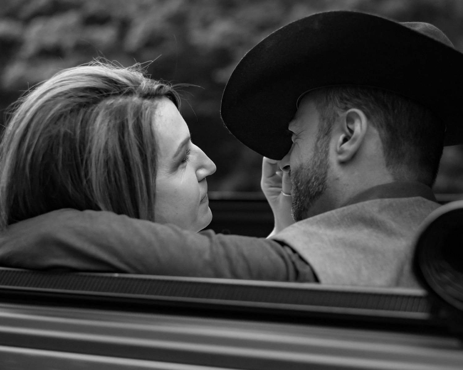 A romantic black and white photo series showing a couple sharing intimate moments in a car.