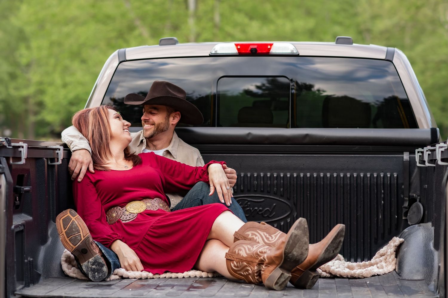 Romantic poses captured on the back of a black pickup truck.