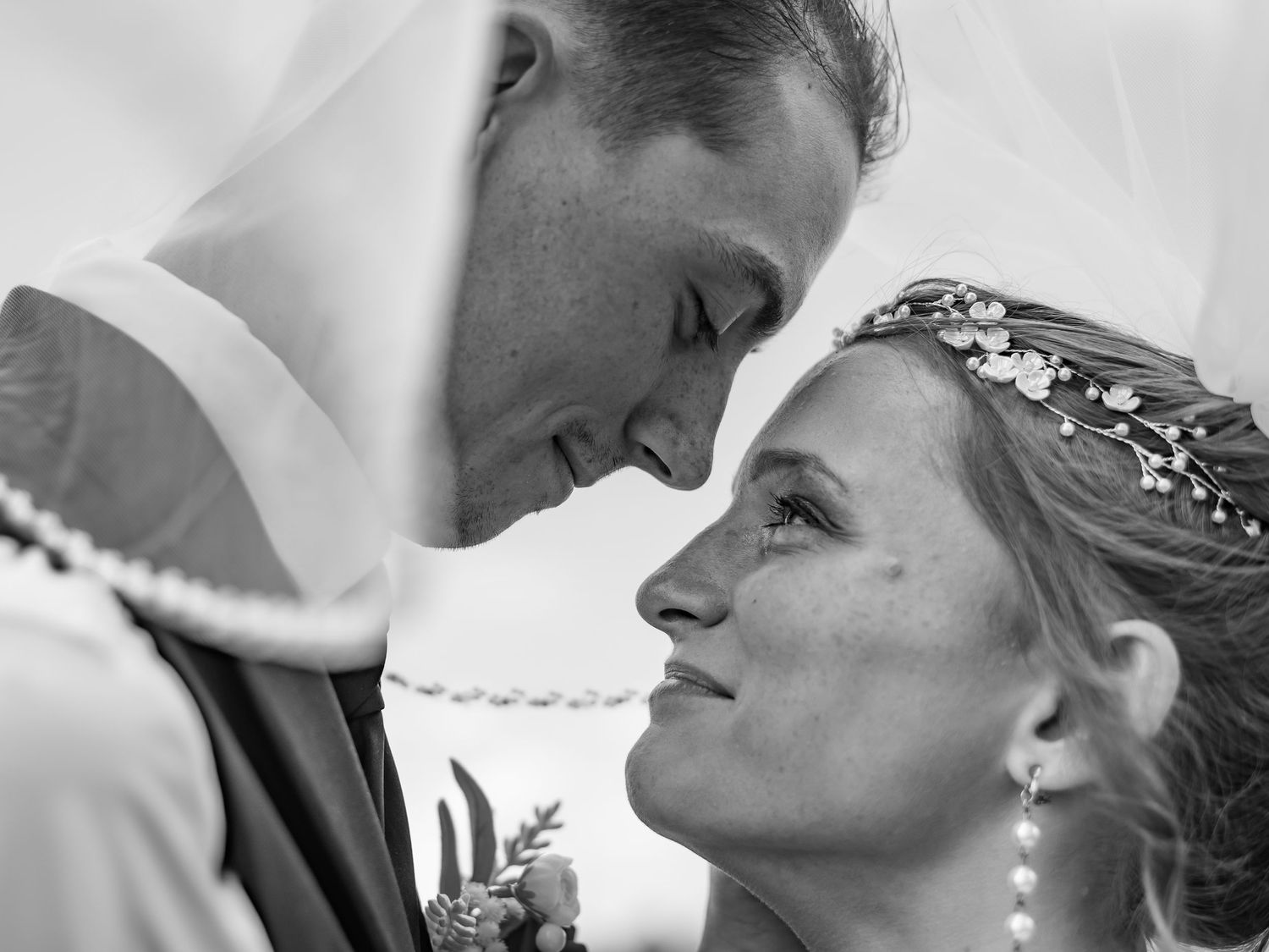 An intimate black and white close-up of a couple sharing a tender moment.