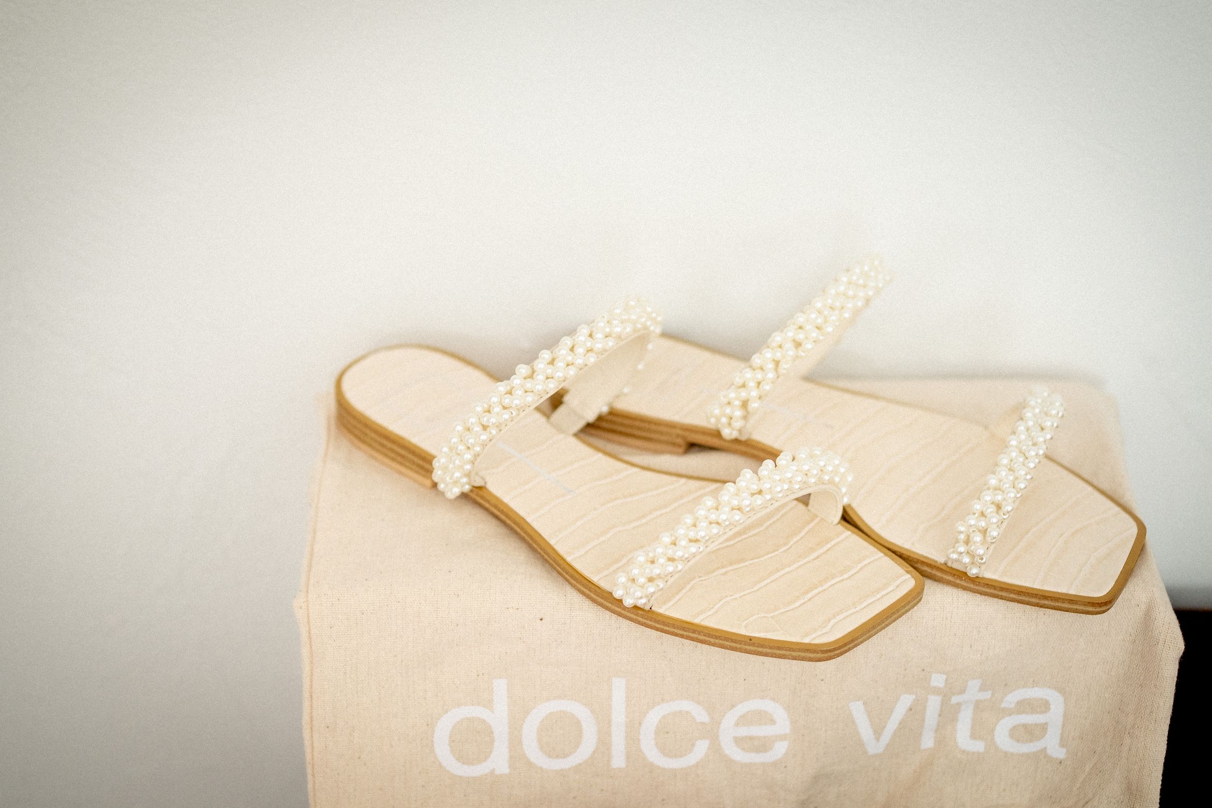 Elegant pearl-embellished bridal shoes displayed against light background.